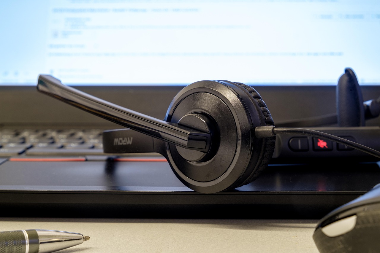 A support headset resting in front of an active computer screen
